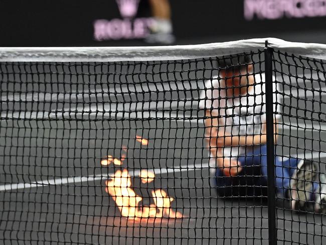 A protester sets his arm alight during the singles game between Greece's Stefanos Tsitsipas and Argentina's Diego Schwartzman at the 2022 Laver Cup in London. Picture: AFP