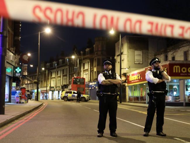 Police officers guard a cordon, set up on Streatham High Road. Picture: AFP