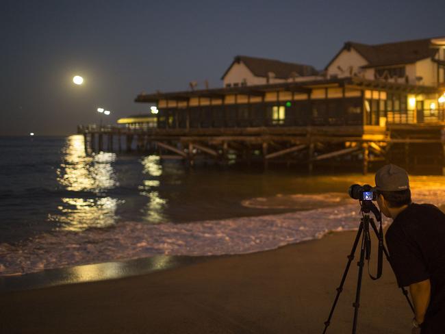 A man photographs the moon as it makes its closest orbit to the Earth since 1948 on November 14, 2016 in Redondo Beach, California. Picture: David McNew/Getty Images/AFP