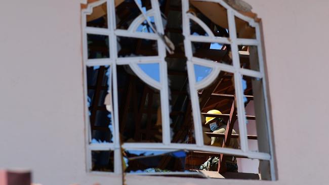 A worker clears debris from the roof of St Sebastian's in Negombo. Picture: AFP