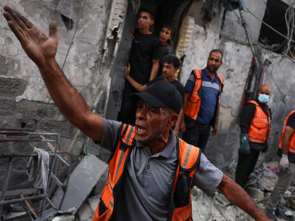 A rescuer reacts during the search for victims or survivors in a car covered by the rubble of a house destroyed in an Israeli strike on Rafah in the southern Gaza Strip. Picture: AFP