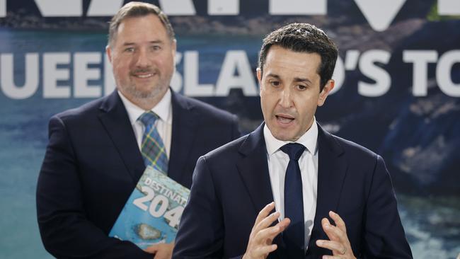 Tourism minister Andrew Powell stands behind Premier David Crisafulli holding the Destination 2045 20-year tourism plan. Photo: Josh Woning