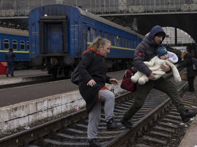 A family crosses the railway line as they continue their journey at the main bus and train terminal in Lviv, Ukraine. Picture: Getty Images