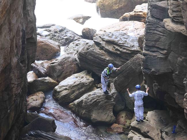 Police work to retrieve the body found at the base of cliffs. Picture: Max Mason-Hubers