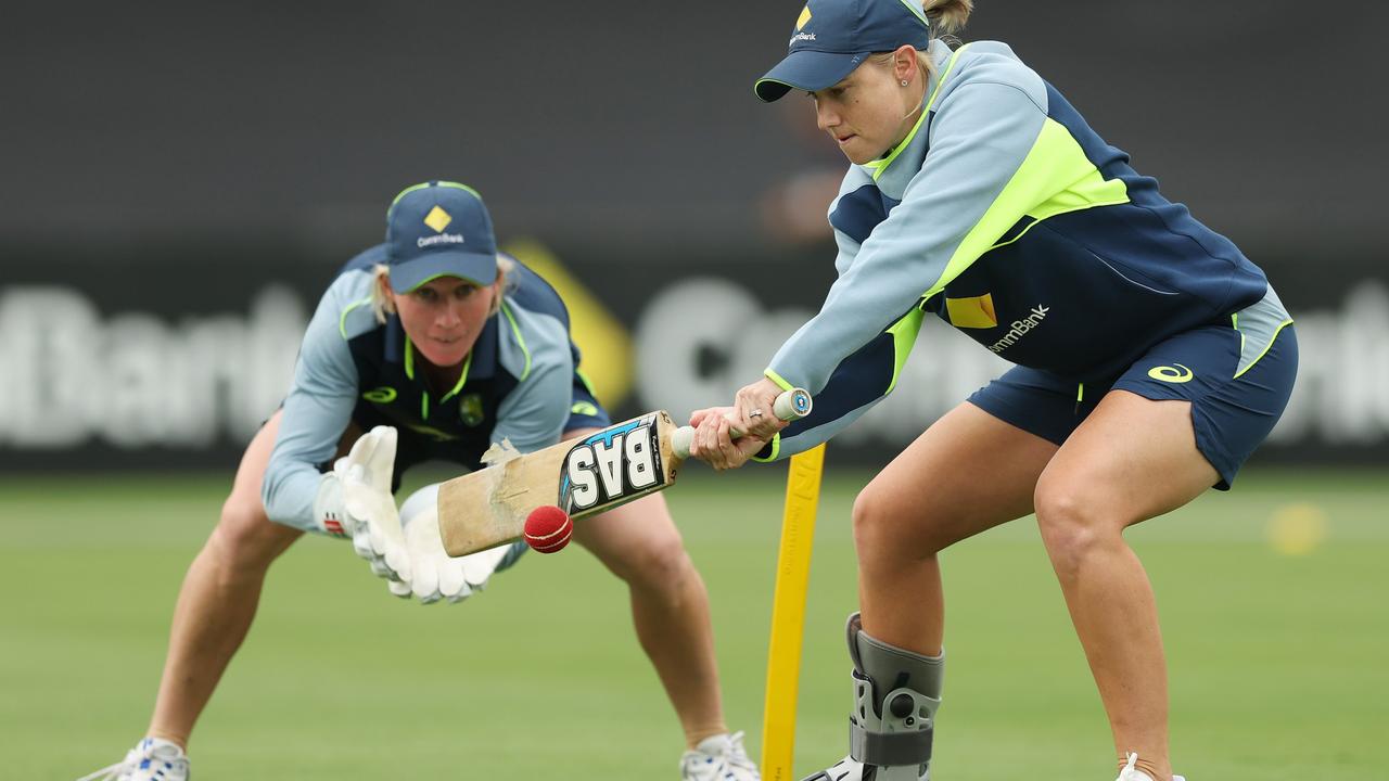 :Injured captain Alyssa Healy wearing a moon boot as she helps out teammates in Canberra . (Photo by Mark Metcalfe/Getty Images)