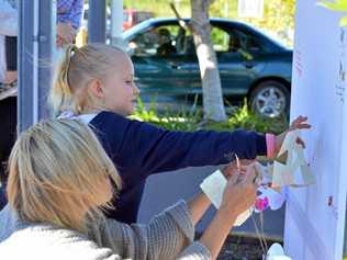 Flowers and messages have been left by Leonie Gilbertson and her daughter Aylah, 6, to pay their respects to the family of the little girl who died in Nambour afterbeing struck by a car on a pedestrian crossing. Picture: Patrick Woods