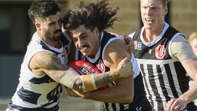 Port Adelaide’s Lachie Jones is collared in a tackle by South Adelaide’s Eamon Wilkinson at Alberton Oval. Picture: Matt Loxton