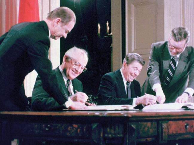 US President Ronald Reagan (2nd R) and Soviet leader Mikhail Gorbachev (2nd L) sign their names on the leather-bound treaties a signing ceremony for the Intermediate Range Nuclear Forces Treaty in the White House East Room in Washington, DC in 1987. Picture: Supplied