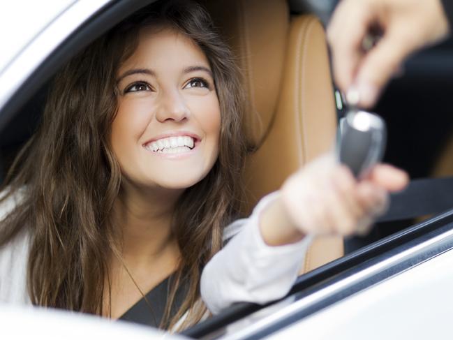 Young woman receiving the keys of her new car