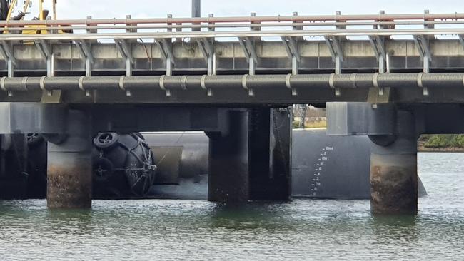 A crew member can be seen standing on top of the submarine HMAS Collins, which is docked in Pinkenba. Picture: Alistair Bulmer