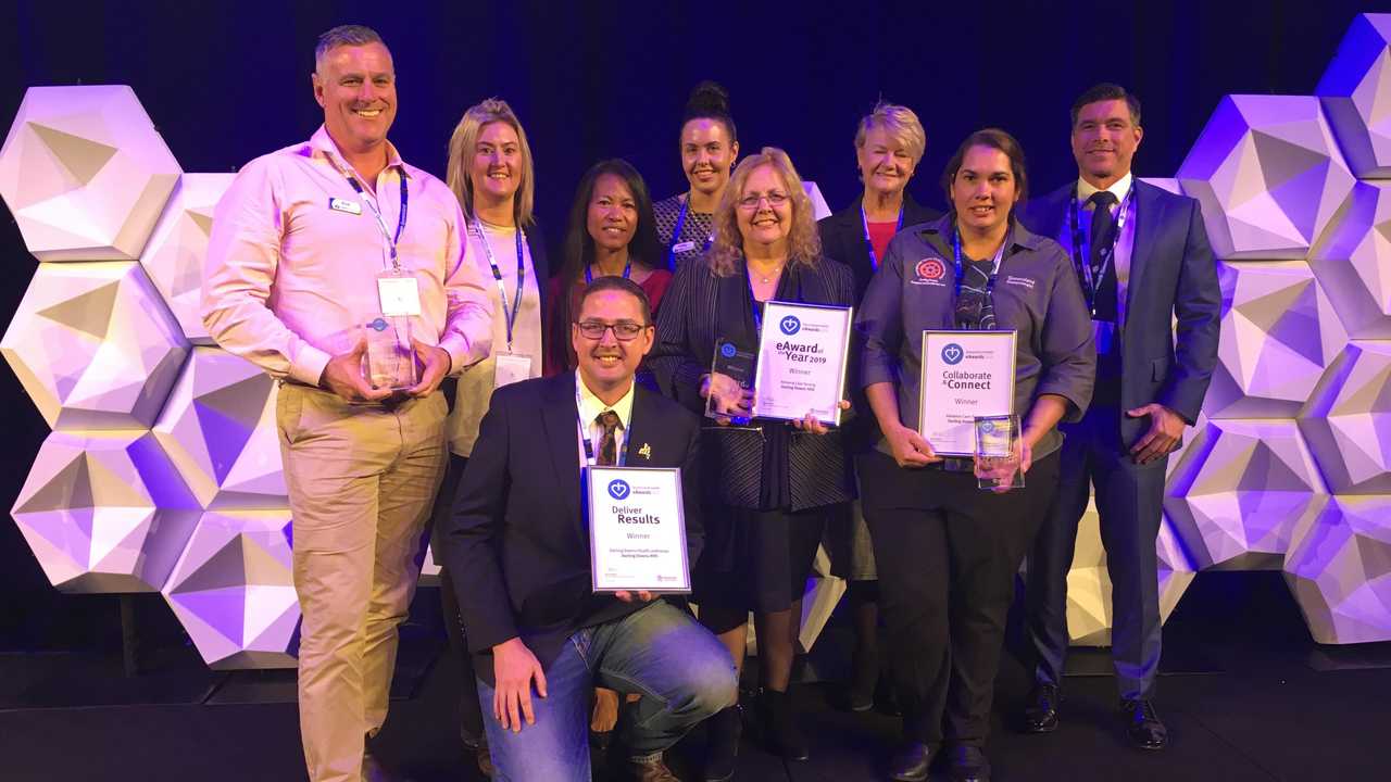 ACHIEVEMENT: Accepting their eAwards are Darling Downs Health staff members (from left) Rodney Nesbitt, Michelle Cleary, Tess Wootton, (front, kneeling) Dr Daniel Halliday, Sally Norton, Lorraine McMurtrie, Denise Pambid of Darling Downs and West Moreton PHN and Karen Johnson with judge Rupert Lee from the Australian Digital Health Agency.