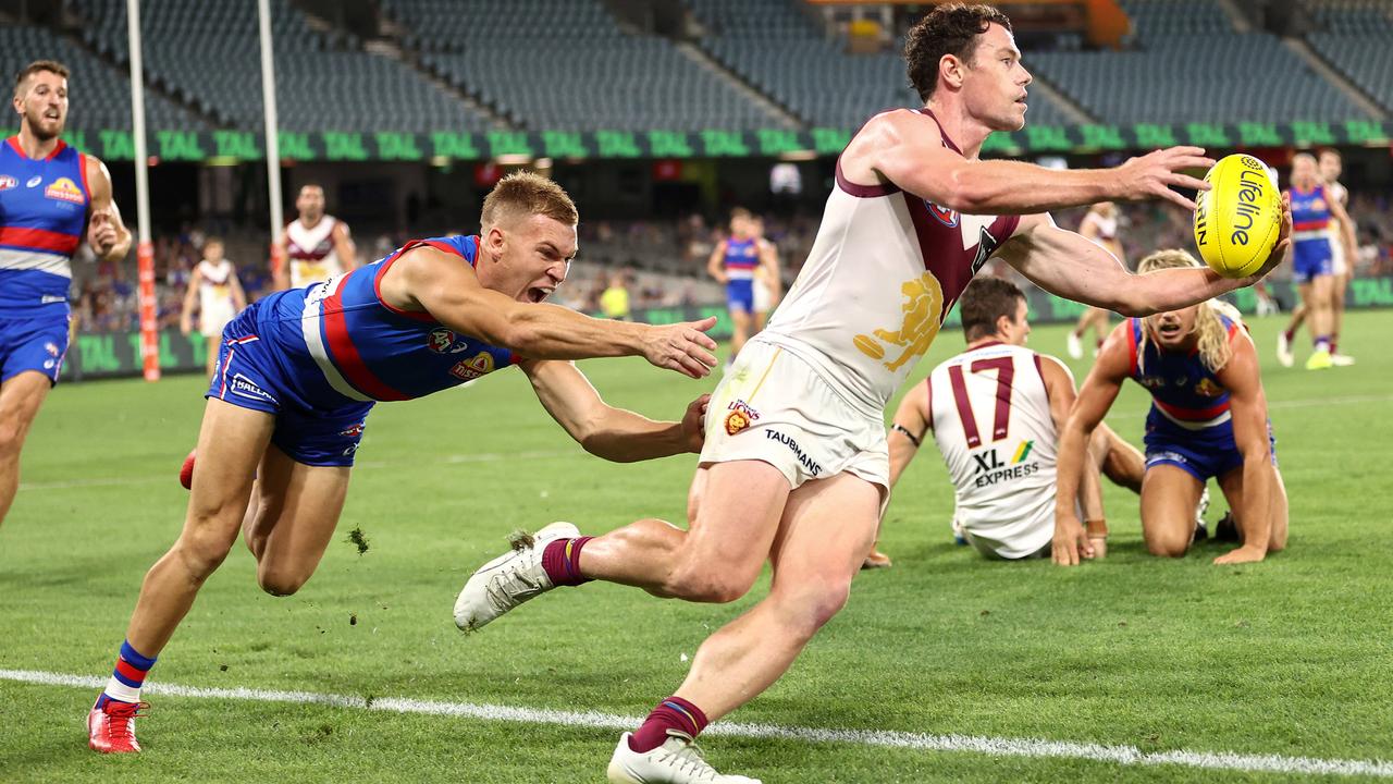 Brisbane Lion Lachie Neale tries to keep the ball in as he runs along the boundary line during a match against the Western Bulldogs at Marvel Stadium. A microchip in the ball would show if the ball was kept in or crossed the line. Picture: Michael Klein