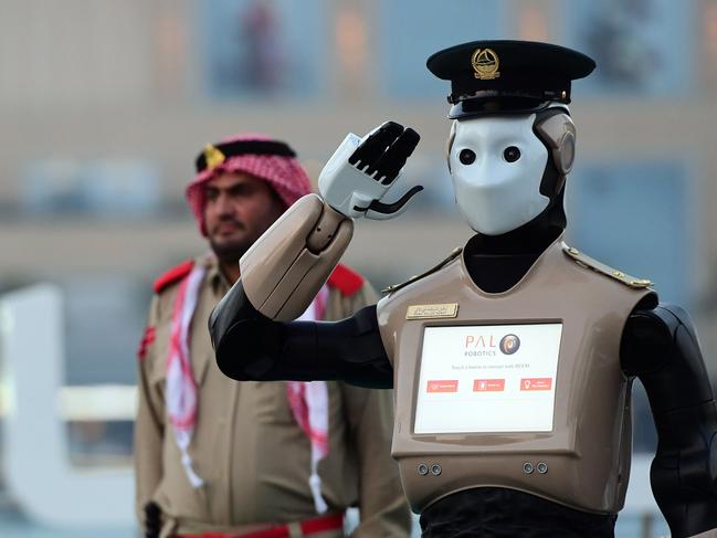 The world's first operational police robot stands at attention they prepare military cannon to fire to mark sunset and the end of the fasting day for Muslims observing Ramadan, in Downtown Dubai on May 31, 2017.