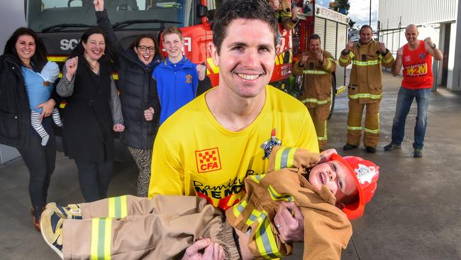 Damien's son Anthony Burke, also a firefighter, runs with his son Ethan with support from his family and fellow firefighters. Picture: Tony Gough