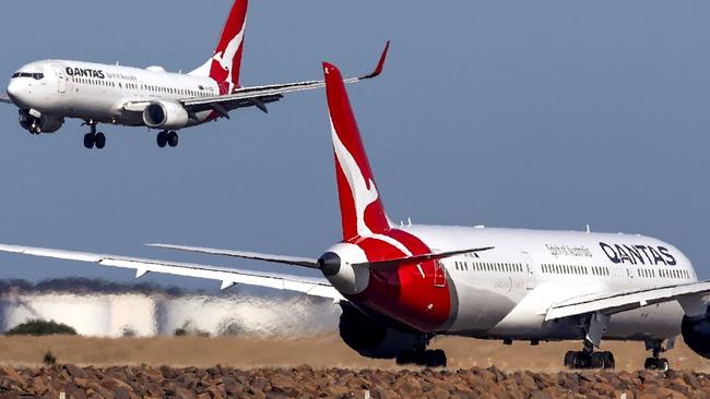 This photo taken on September 4, 2024 shows a Qantas Airways Boeing 737-800 plane coming in to land next to a Qantas Airways Boeing 787 Dreamliner aircraft preparing to take-off at Sydney International Airport. (Photo by DAVID GRAY / AFP)