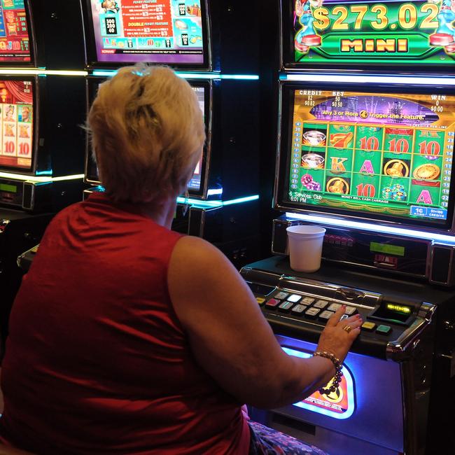 A woman tries her luck on a pokie machine. Picture: generic