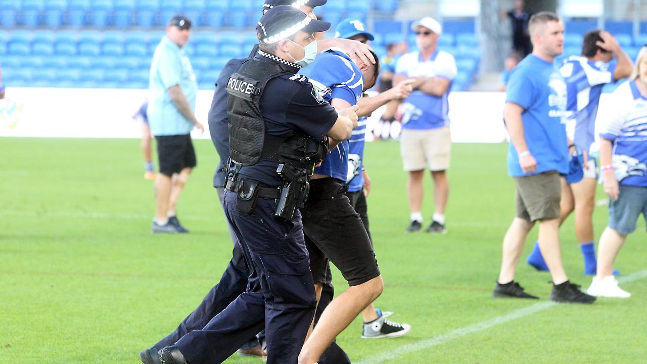 A man is escorted off the ground after the Tugun Seahawks v Currumbin Eagles reserve grade Grand Final. Picture by Richard Gosling