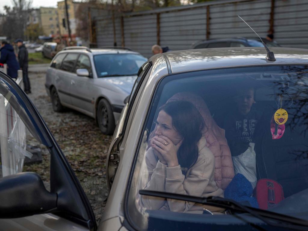 A Ukranian woman sits in a car with her family after they managed to flee from the Russian occupied territory of Kherson. Picture: Bulent Kilic / AFP