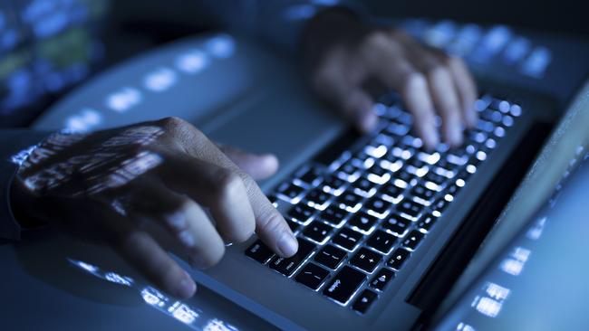 Close-up image of coder typing on computer