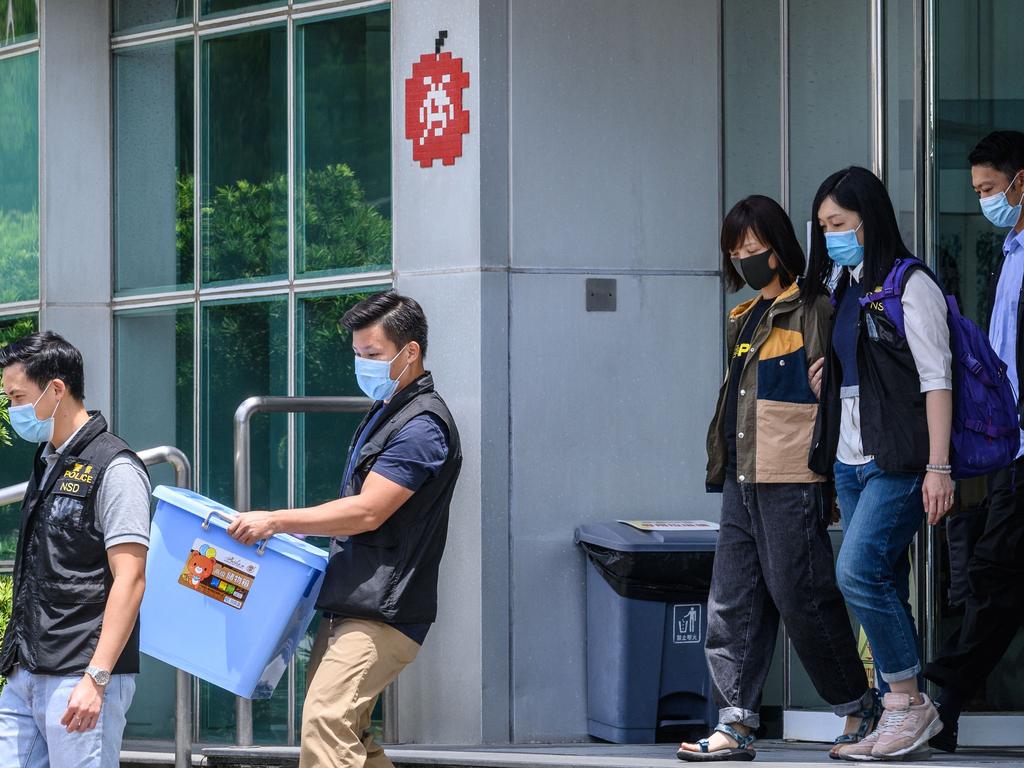 Police escort Apple Daily Deputy Chief Editor Chan Pui Man (3rd R) to a waiting vehicle from the offices of the local Apple Daily newspaper in Hong Kong.