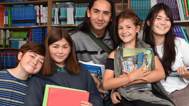 The Glenny family are struggling to cover the cost or both primary and secondary education this year. They are at the Les Twentyman Foundation headquarters with books and stationary. (L-R) Addicus (11), Celeste (14), David Glenny (dad), Uaria (11) and Lenoir (15). Picture: Josie Hayden