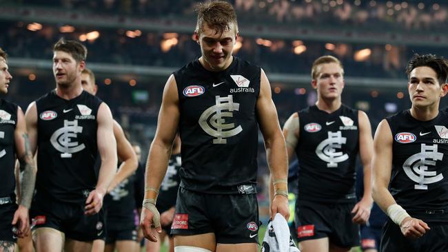 Carlton players walk off after a loss.