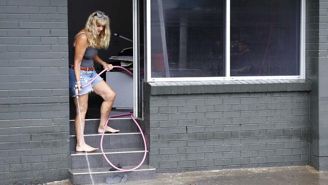 A woman cleaning up outside a business in Milton. Picture: Tertius Pickard