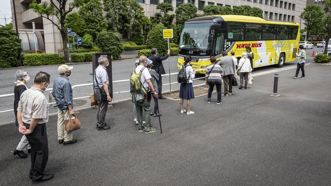 Elderly people queue to take a shuttle bus after getting vaccinated at the Tokyo mass vaccination site this week. Picture: Getty Images