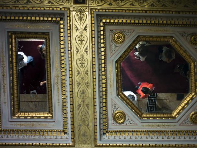 Visitors are reflected in the mirror-patched ceilings.