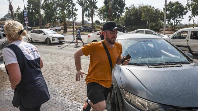 People in the southern Israeli city of Ashkelon run for cover as sirens warn of incoming rockets from nearby Gaza on October 11. Picture: AFP