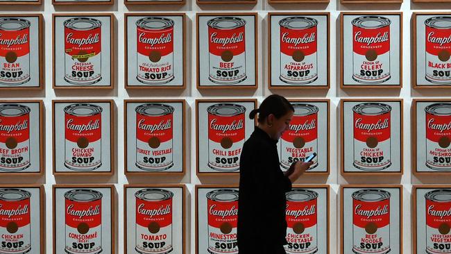 A woman walks past Andy Warhol’s Campbell's Soup Cans at the newly expanded Museum of Modern Art. Picture: AFP.