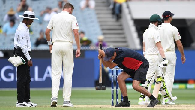 A groundsman works on the MCG pitch on Day 5.