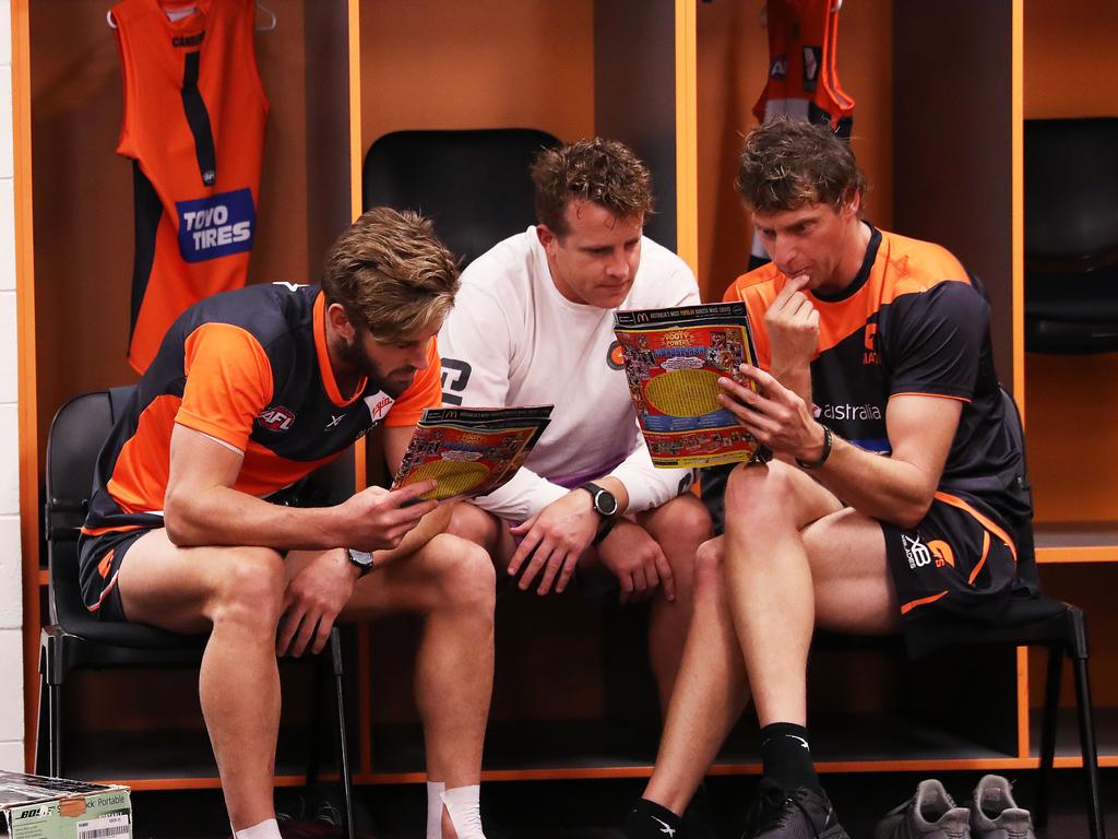 Callan Ward with staff reads the footy record. Picture: Phil Hillyard