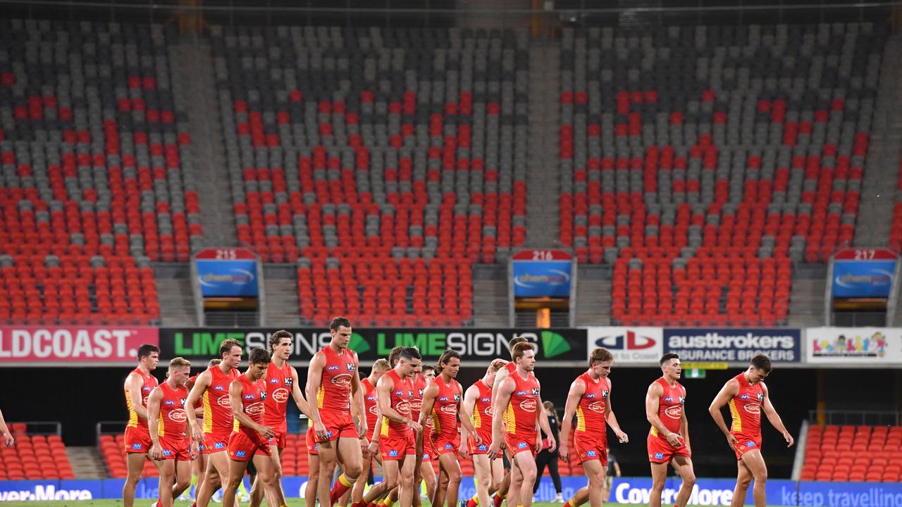 Gold Coast players depart Metricon Stadium on Saturday night.