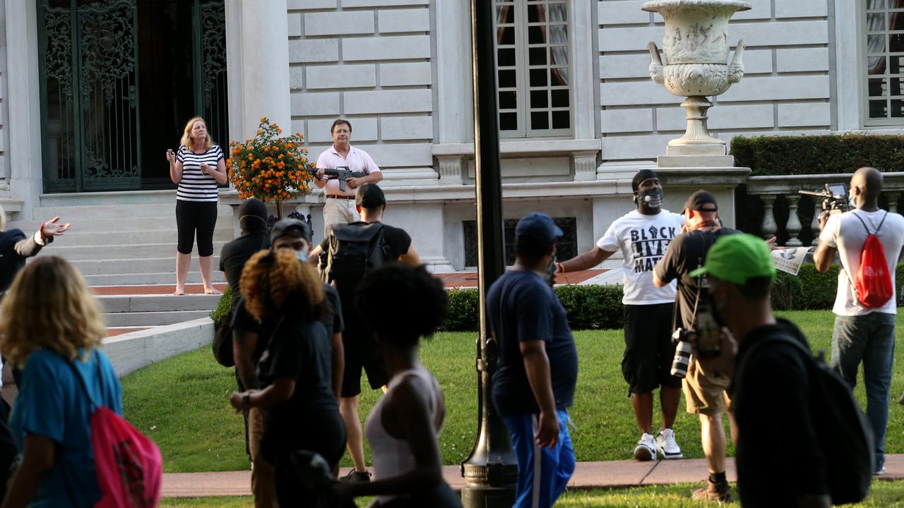 Barefoot but armed, the couple came out waving the weapons as the protesters marched through the exclusive neighbourhood. Picture: Laurie Skrivan/St. Louis Post-Dispatch via AP