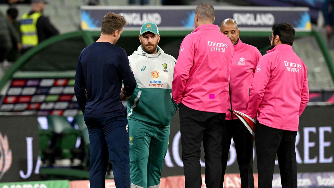 Australia's Captain Aaron Finch (2nd L) skakes hands with England's Captain Jos Buttler (L) when the match was called.