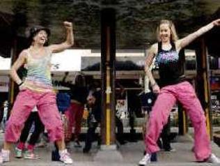 Dance on: Zumba Instructors Tessa Brauer (left), Josie Robertson and other flash mob dancers from Summit Sports and Fitness Centre stopped traffic in the middle of Woodlark Street yesterday in an effort to promote healthy lifestyle. Picture: Jay Cronan