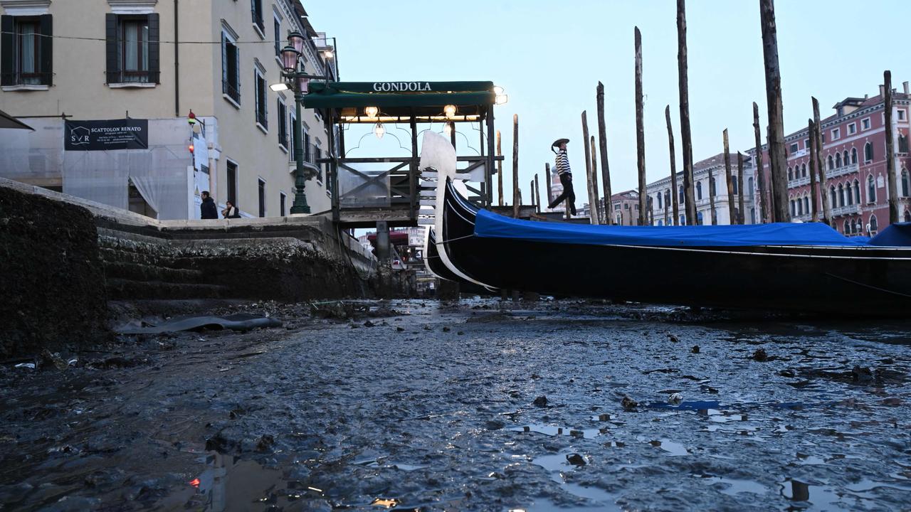 This photograph taken on February 20, 2023, shows gondolas tied up in Venice Canal Grande, during a severe low tide in the lagoon city of Venice. Picture: Marco Sabadin/AFP
