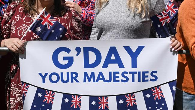 A sign is displayed as people wait to greet Britain's King Charles III and Queen Camilla. Picture: AFP