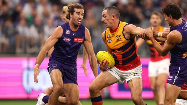 PERTH, AUSTRALIA - APRIL 25: Taylor Walker of the Crows gets tackled by Alex Pearce and Heath Chapman of the Dockers during the round seven AFL match between Fremantle Dockers and Adelaide Crows at Optus Stadium, on April 25, 2025, in Perth, Australia. (Photo by Paul Kane/Getty Images)