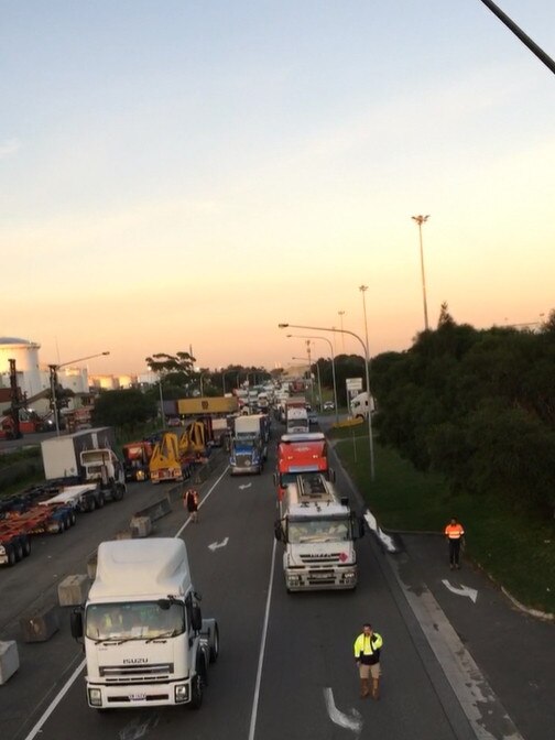 The activist suspended themselves in the air from poles at the entrance to Port Botany.