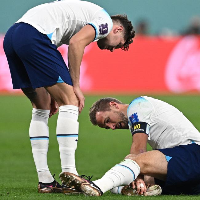 Harry Kane assesses his ankle after being hurt.