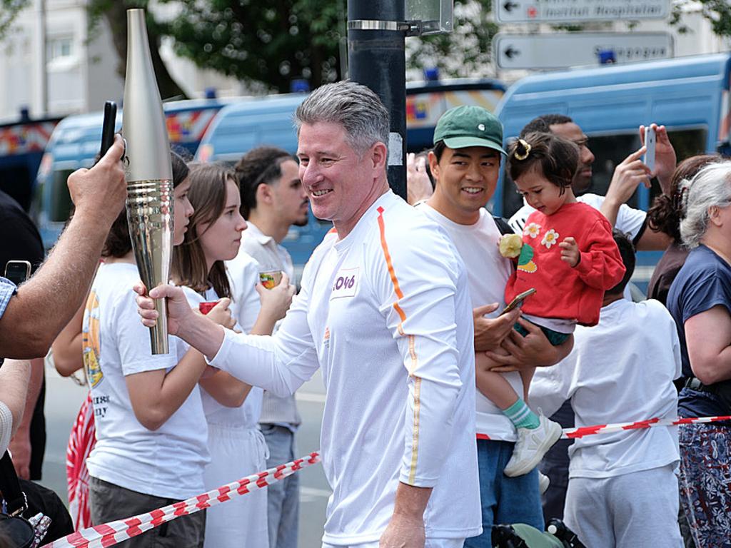 Nine CEO Mike Sneesby carries the Paris Olympics torch in the Olympic torch relay. Picture: Jacquelin Magnay