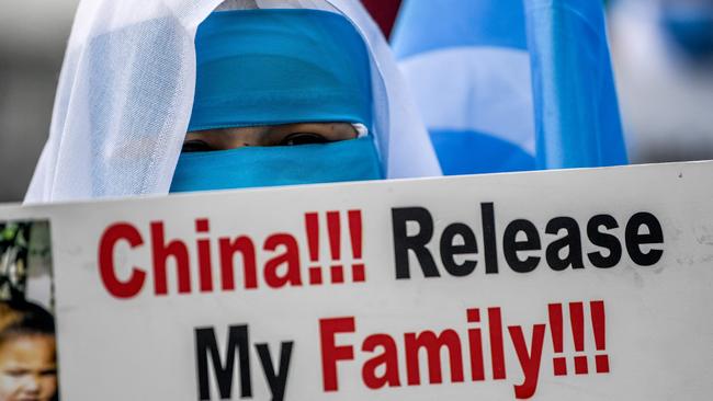 Members of Women Muslim Uighur minority hold placards and flags as they demonstrate to ask for news of their relatives. Picture: AFP