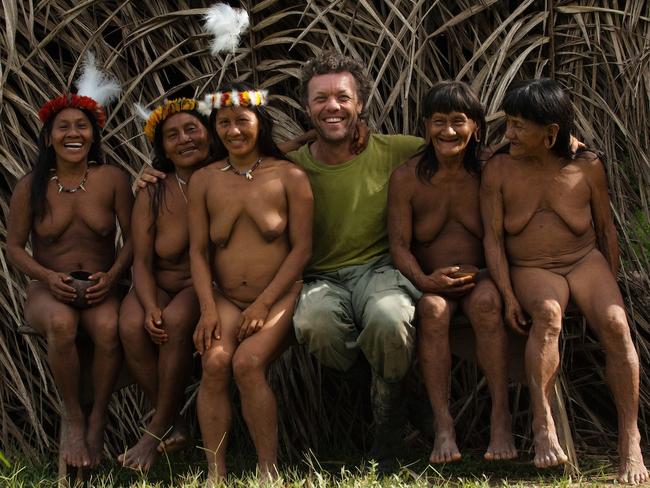Photographer Pete Oxford poses for the camera with women from the Huaorani tribe. Picture: Pete Oxford/mediadrumworld.com