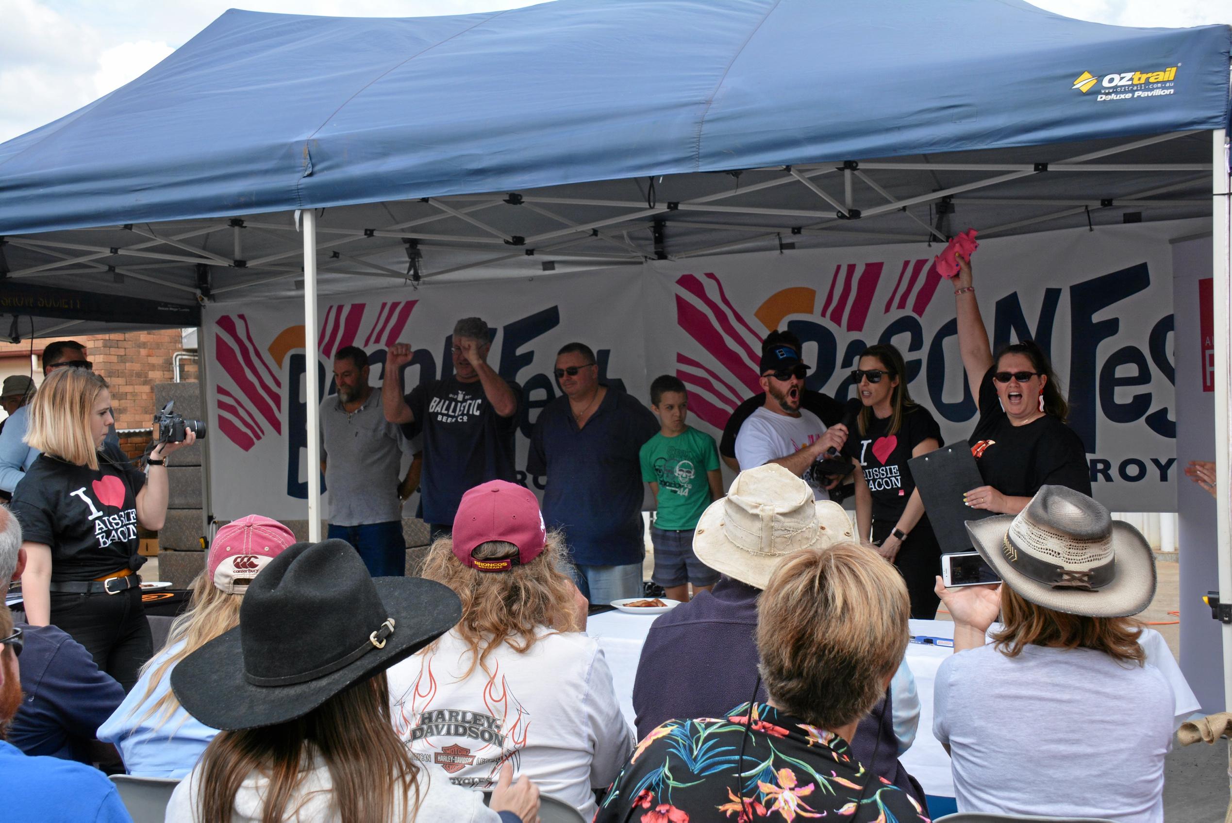 SQUEAL: Competitors line up for the bacon eating competition as South Burnett Cr Danita Potter demonstrates the squealer during Kingaroy's BaconFest on Saturday August 25. Picture: Jessica McGrath