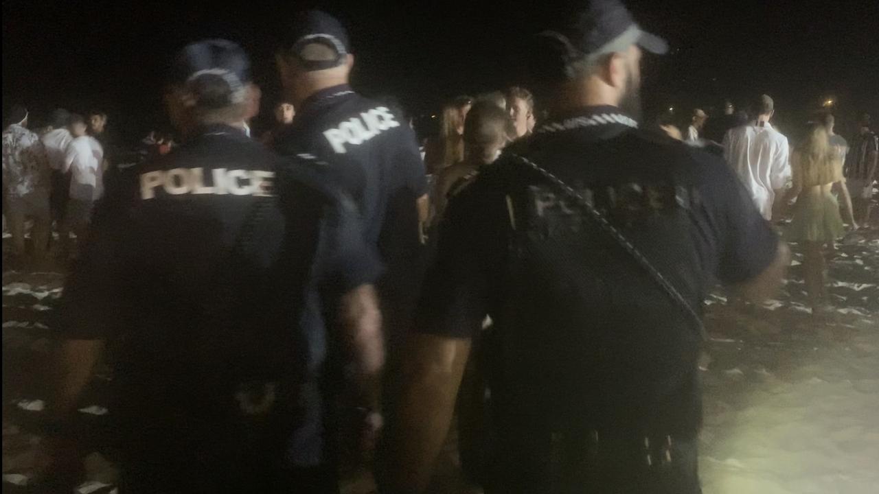 Police patrol Noosa Main Beach during a huge Schoolies gathering.