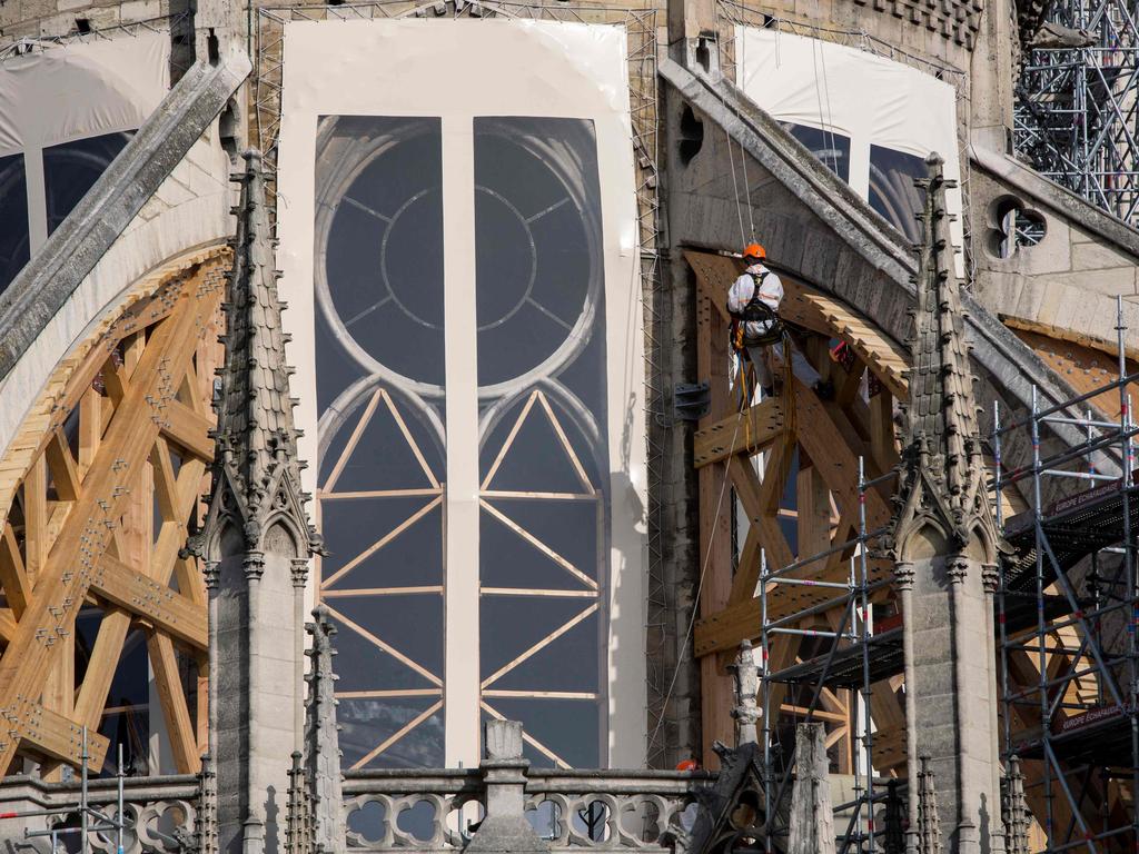 A construction worker rappels down the cathedral during preliminary work in July 24. Picture: Rafael Yaghobzadeh/Pool/AFP