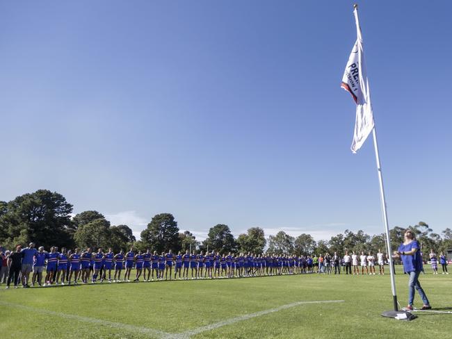 Cathy White unfurls the premiership flag. Picture: Valeriu Campan