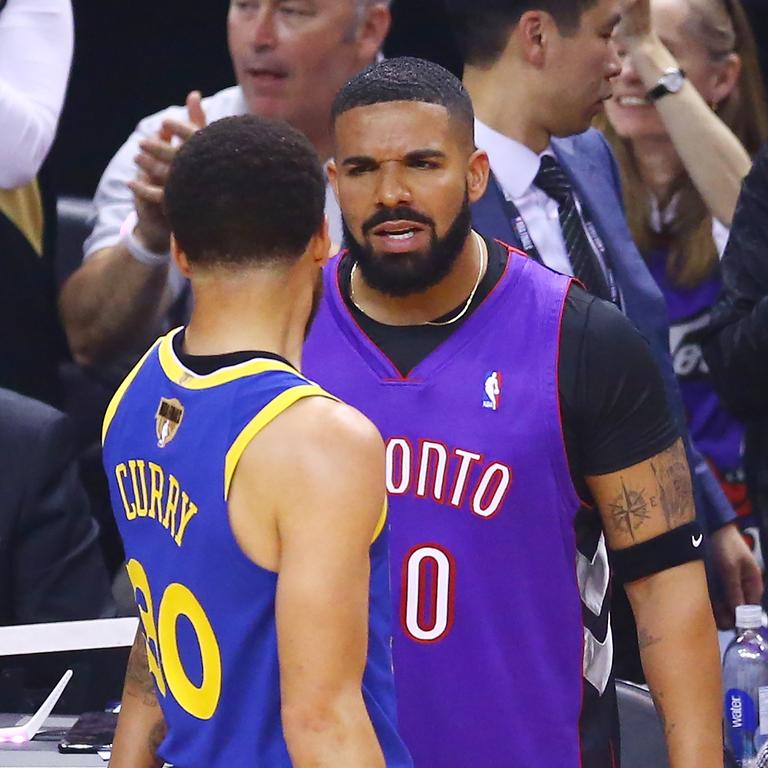 Rapper Drake and Stephen Curry exchange words during the 2019 NBA Finals. (Photo by Vaughn Ridley/Getty Images)